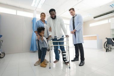 Physiotherapist takes patient to practice walking.