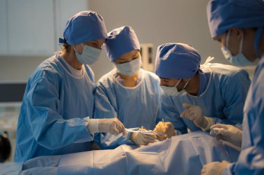 Doctor, nurse doing surgery on patient in operating room.