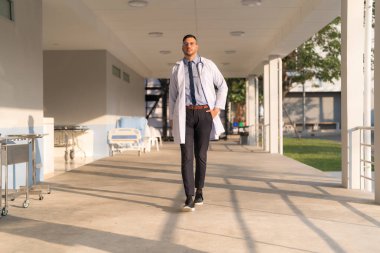Doctor doing different poses in hospital with smiling face bright and friendly.