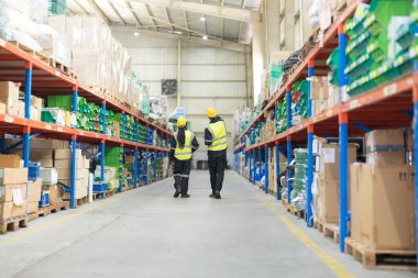 Warehouse workers and managers check stock and inventory that fills shelves Working in logistics distribution center. clipart