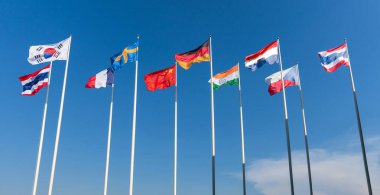 Dokuz ülkenin, Tayland, Güney Kore, Fransa, İsveç, Çin, Almanya, Çek Cumhuriyeti, Hollanda, Hindistan 'ın ulusal bayrakları mavi gökyüzüne karşı dalgalanıyor.