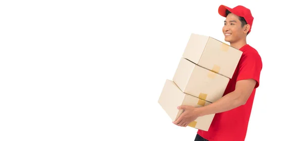 那个面带微笑的送货人身穿红帽子和空白T恤制服 站在一个白色背景的前面 手里拿着空白的纸板箱 — 图库照片