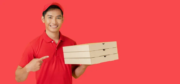 Usměvavý Poslíček Pizzy Stojí Červeném Pozadí Drží Krabici Pizzy Sobě — Stock fotografie