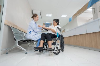 The doctor inquired and examined the patient's health in a wheelchair with a friendly manner.