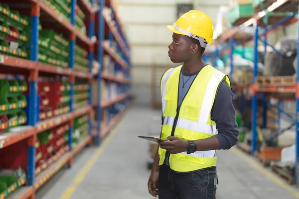 stock image Male factory manager standing laptop to inspect the products in the warehouse while looking at the products on the shelves