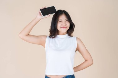 Bir kadın akıllı telefonunu kullanarak eğleniyor ve mutlu oluyor.