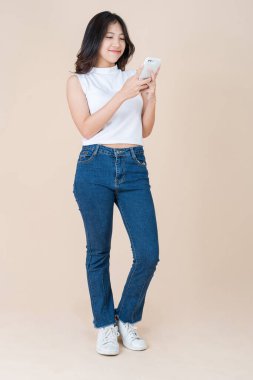 Bir kadın akıllı telefonunu kullanarak eğleniyor ve mutlu oluyor.