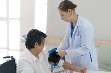 Elderly woman checking blood pressure To check the health of the body by the doctor for advice.