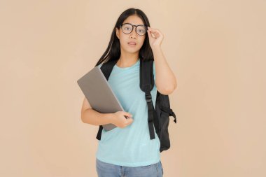 Mutlu Asyalı kız öğrenci gözlük takıyor ve elinde bir tablet var.