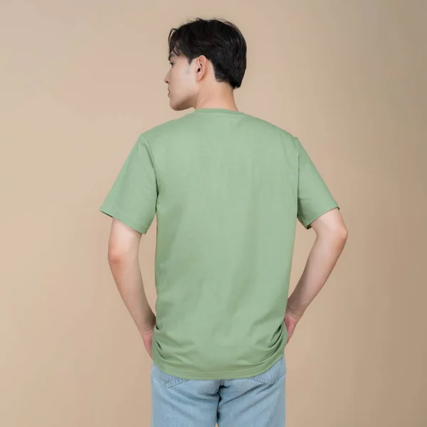 Male Fashion Model Green Shirt Jeans Standing Studio Beige Background — Stock Photo, Image