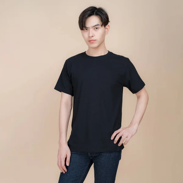 Male Fashion Model Black Shirt Jeans Standing Studio Beige Background — Stock Photo, Image