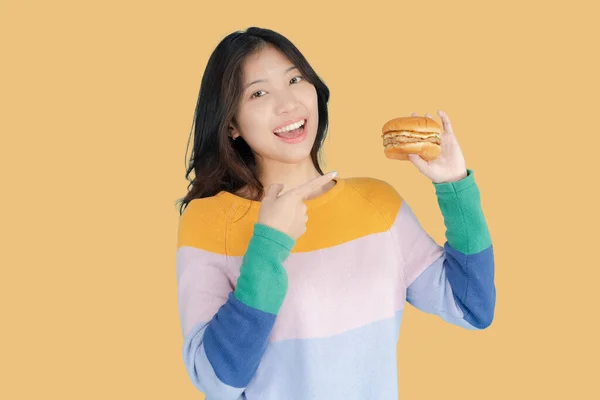 아름다운 여자가 배경으로 햄버거를 행복하게 — 스톡 사진