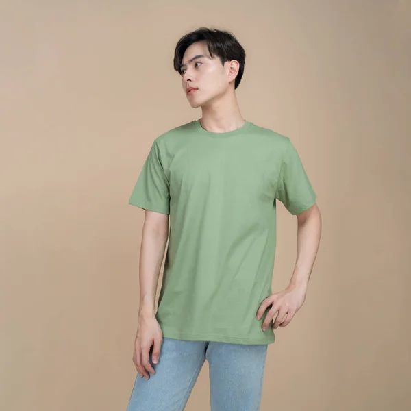 Male Fashion Model Green Shirt Jeans Standing Studio Beige Background — Stock Photo, Image