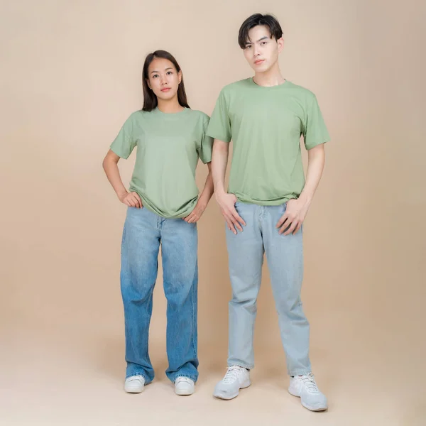 Obraz Modela Męskiego Żeńskiego Stojącego Zielonej Koszulce Dżinsach Stojących Studio — Zdjęcie stockowe