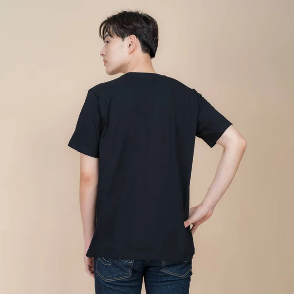 Mužský Módní Model Černém Tričku Džínách Stojící Studiu Béžovém Pozadí — Stock fotografie