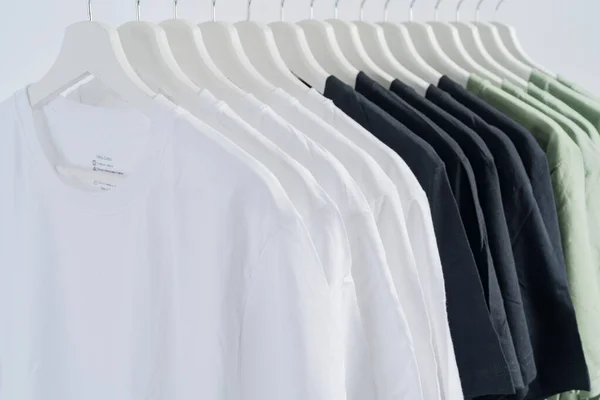 特写系列黑白绿相间的T恤衫挂在木制衣架上 服装背景 — 图库照片