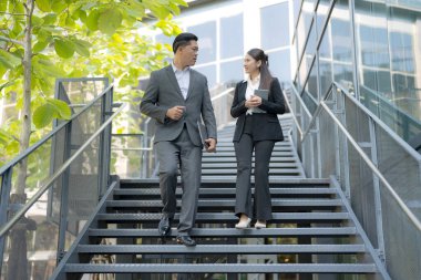 Takım elbiseli iki profesyonel açık hava merdivenlerinden inerken tartışıyorlar.