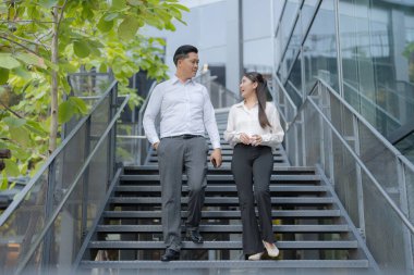 Dışarıdan inerken sohbet eden iki profesyonel.