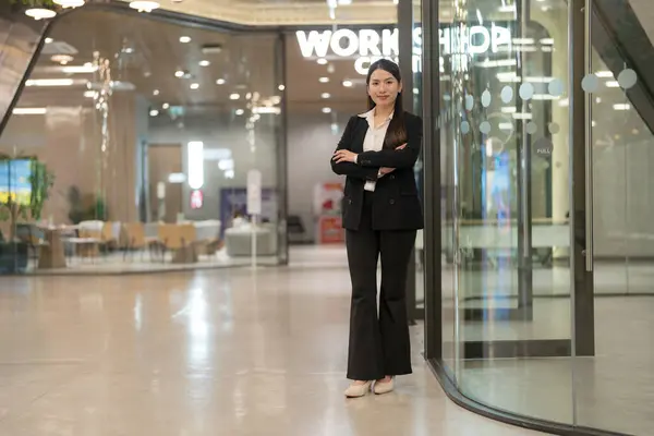 Professional woman in suit smiling outside a modern corporate building