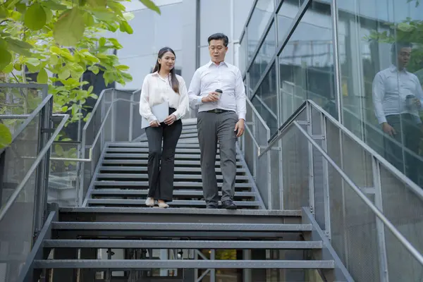 Two professionals in conversation while descending outdoor stairs