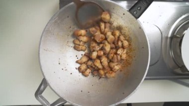 Şef spatulayı ustalıkla bir tavada domuz eti kızartmak için kullanıyor, ağız sulandırıcı ve lezzetli bir yemek yaratıyor zengin tatlar ve nefis aromalar.
