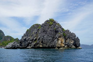 El Nido Takımadası 'ndaki mavi denizde devasa kireçtaşı kayaları.