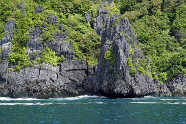 El Nido Takımadası 'ndaki mavi denizde devasa kireçtaşı kayaları.