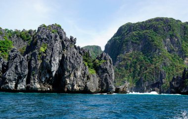 El Nido Takımadası 'ndaki mavi denizde devasa kireçtaşı kayaları.