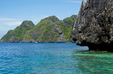 El Nido Takımadası 'ndaki mavi denizde devasa kireçtaşı kayaları.