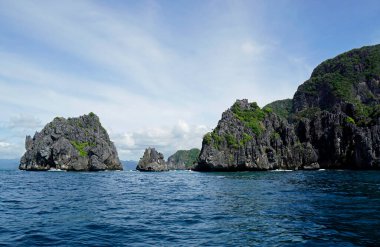 El Nido Takımadası 'ndaki mavi denizde devasa kireçtaşı kayaları.