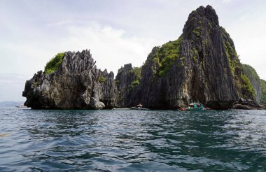 El Nido Takımadası 'ndaki mavi denizde devasa kireçtaşı kayaları.