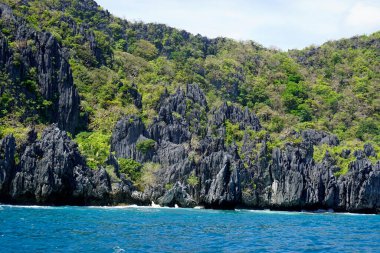 El Nido Takımadası 'ndaki mavi denizde devasa kireçtaşı kayaları.