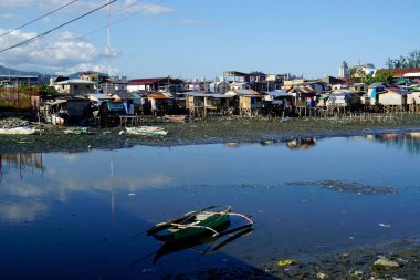Cebu, Filipinler, Şubat 2023 - zavallı adam bir nehrin kıyısında çömelmiş.