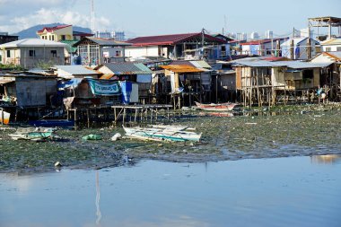 Cebu, Filipinler, Şubat 2023 - zavallı adam bir nehrin kıyısında çömelmiş.