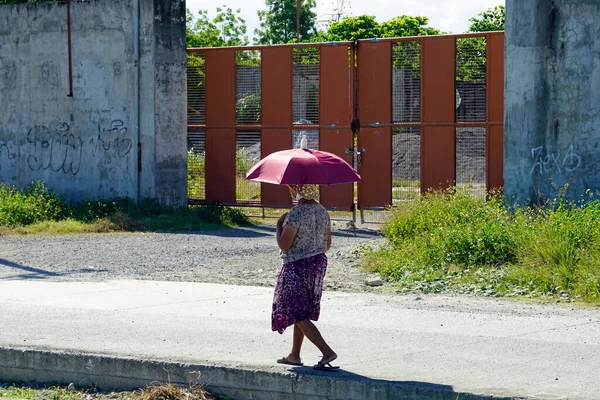 2023年3月頃 セブのコルドバ島 漁師の村を歩く老女が傘の下に隠れて — ストック写真