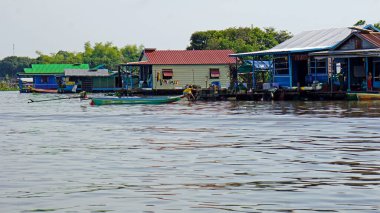 Kamboçya 'da siem hasadının yakınındaki tonle özsuyunda yüzen evler.
