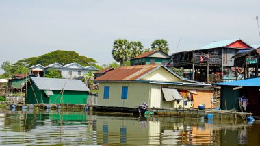 Kamboçya 'da siem hasadının yakınındaki tonle özsuyunda yüzen evler.