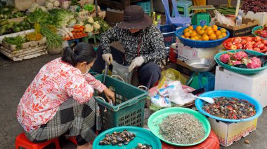 Battambang, Cambida - Ocak 2024: Yerel satıcılar ürünlerini sokak pazarında satıyorlar