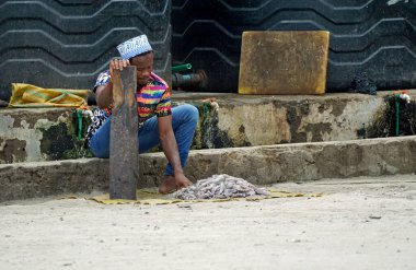 nungwi, zanzibar - Ekim 2024: Genç yetişkin adam yerel balıkçıda taze ahtapot hazırlıyor