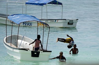 Paje, Zanzibar - Ekim 2024: Yerli çocuklar tekneden atlarken eğleniyorlar