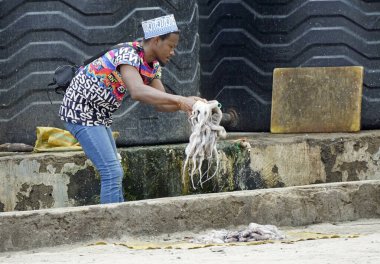 nungwi, zanzibar - Ekim 2024: Genç yetişkin adam yerel balıkçıda taze ahtapot hazırlıyor