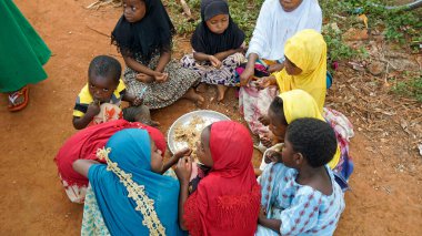 Kinyasini, Zanzibar - Ekim 2024: pirinç yemeği için kirli zeminde oturan yerel ödlek