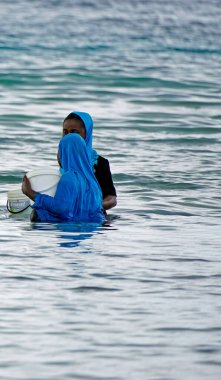 Nungwi, Zanzibar - Ekim 2024: Sular çekildiğinde okyanustan deniz ürünleri toplayan kadın