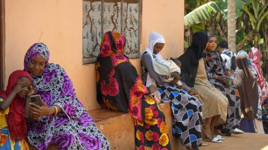 Kinyasini, Zanzibar - Ekim 2024: sakinler basit evlerinin önünde oturuyorlar