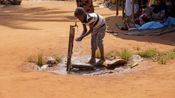 Nungwi, Zanzibar - Ekim 2024: Fakir bir köyde içme suyu sağlanan genç çocuk