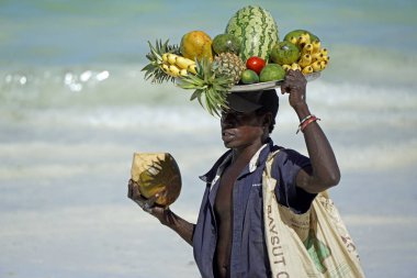 Paje, Zanzibar - Ekim 2024: Kafasında taze meyve taşıyan yerel satıcı