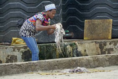 nungwi, zanzibar - Ekim 2024: Genç yetişkin adam yerel balıkçıda taze ahtapot hazırlıyor