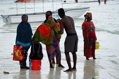 Nungwi, Zanzibar - Ekim 2024: Sular çekildiğinde okyanustan deniz ürünleri toplayan kadın