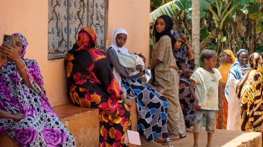 Kinyasini, Zanzibar - Ekim 2024: sakinler basit evlerinin önünde oturuyorlar