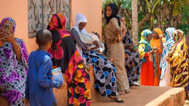 Kinyasini, Zanzibar - Ekim 2024: sakinler basit evlerinin önünde oturuyorlar